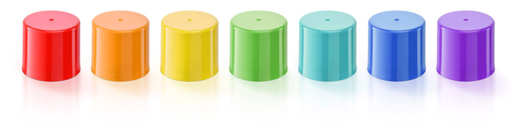 Line up of aerosol caps in different colours in a rainbow effect